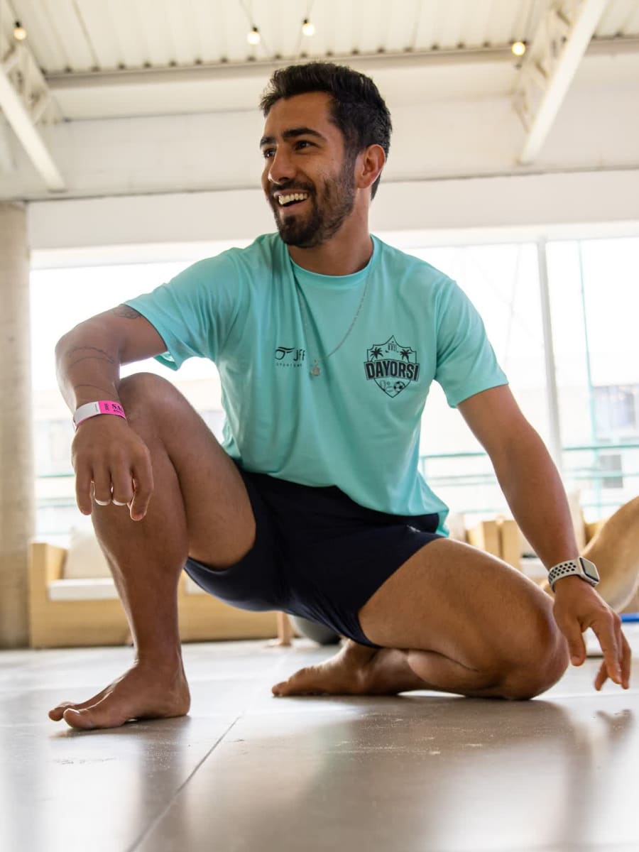 Vander Jordão sorrindo, agachado numa prática de mobilidade