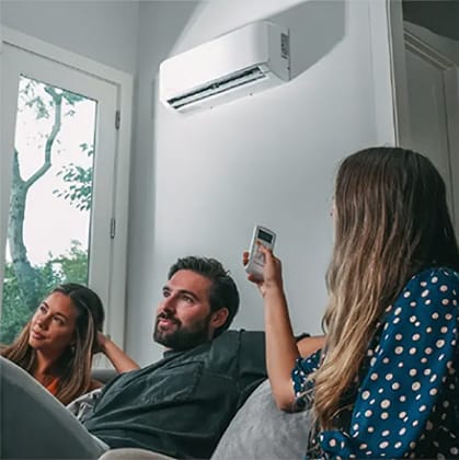 Family using remote control for air conditioner