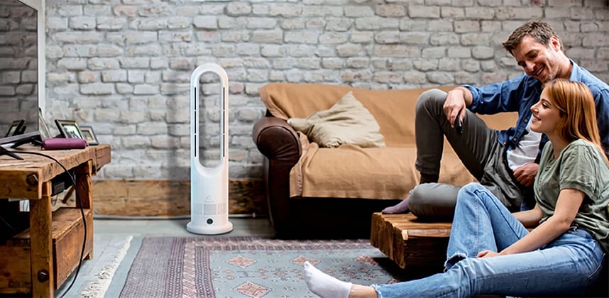 Family relaxing on living room floor with tower fan