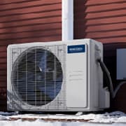 MRCOOL outdoor condenser unit installed beside a building in winter