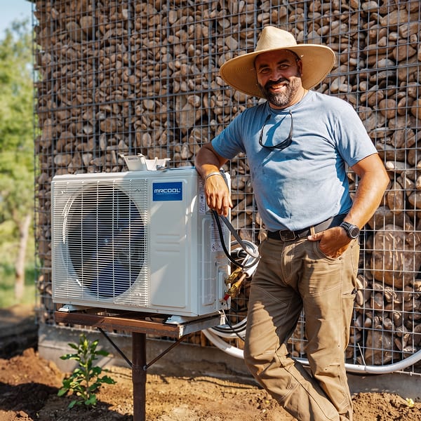 Jared Capp standing beside a MRCOOL DIY outdoor condenser