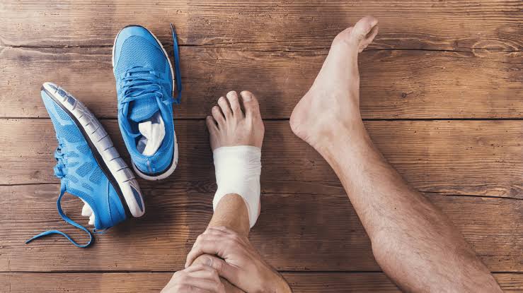 Foto o ilustración genérica de una persona en contexto deportivo amateur sosteniéndose el tobillo o la rodilla, sin sangre ni gestos alarmantes — transmite cuidado del cuerpo, no urgencia médica. Sin logos de marcas, sin camisetas de clubes/selecciones reales, sin rostros identificables de deportistas conocidos.