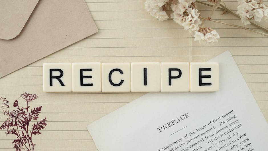 Elegant flat lay featuring recipe letter tiles, dried flowers, and notes on lined paper.
