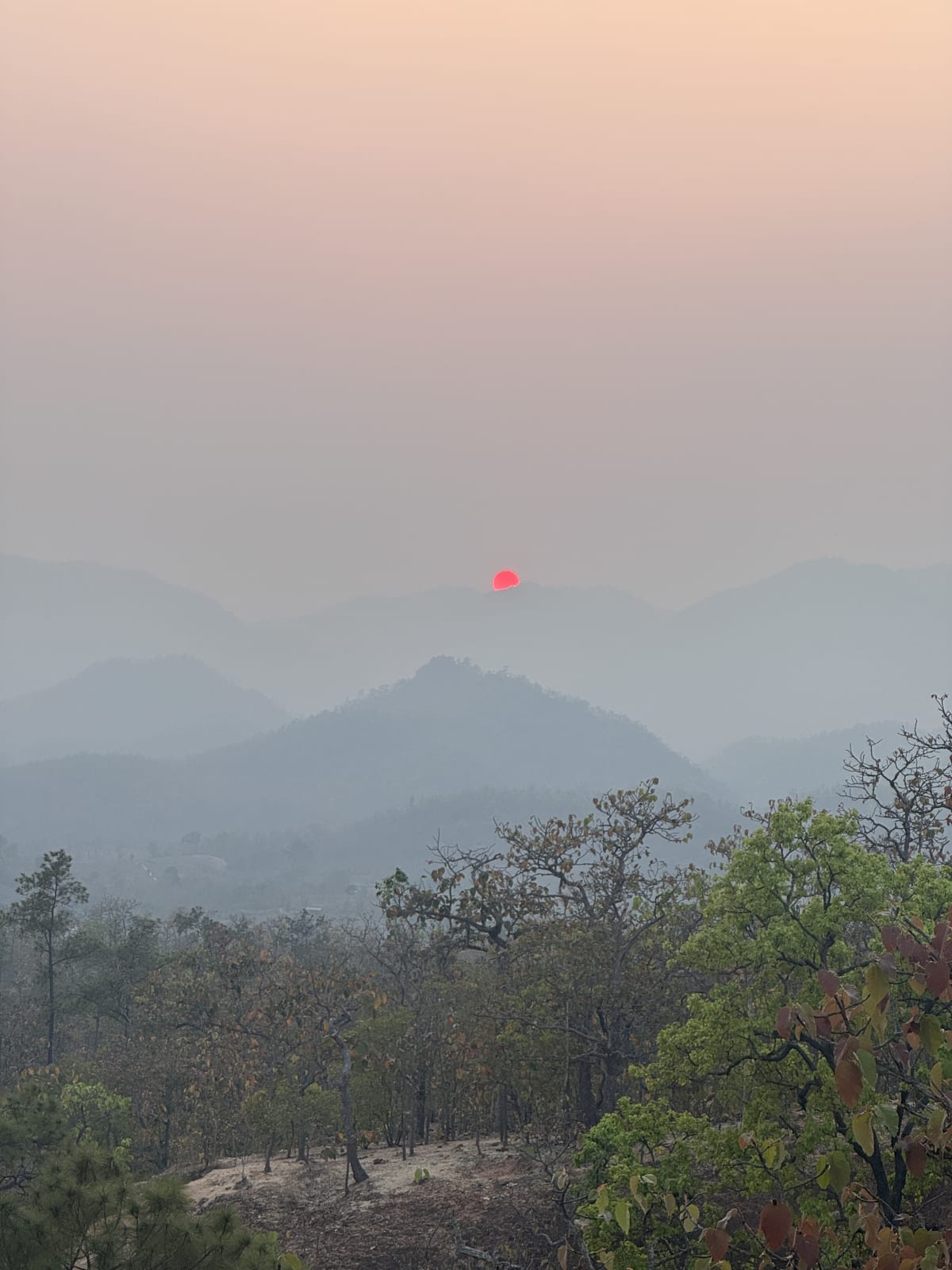 Rode zon boven mistige bergtoppen in Noord-Thailand