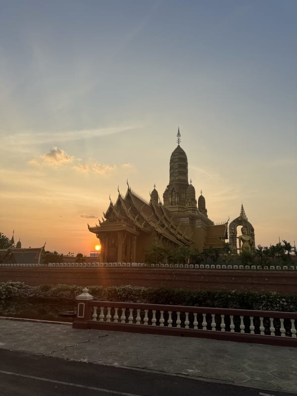 Silhouet van een Thaise tempel tegen een oranje zonsondergang