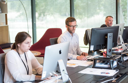 Collègues travaillant sur ordinateurs de bureau