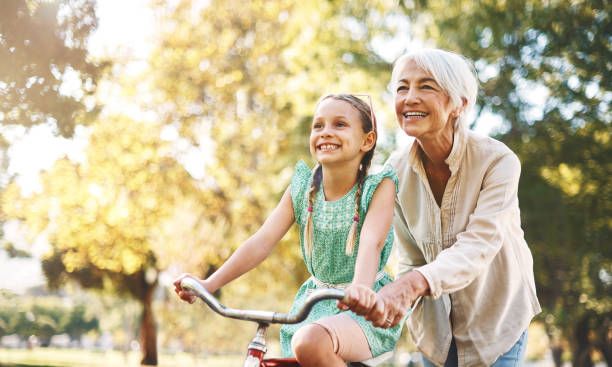 Grand-mère apprenant à faire du vélo à sa petite-fille