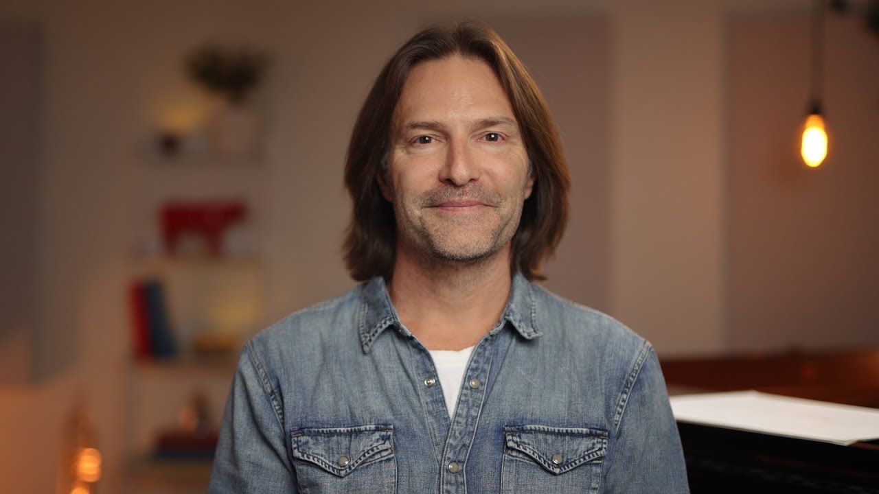 Eric Whitacre smiling portrait in denim shirt