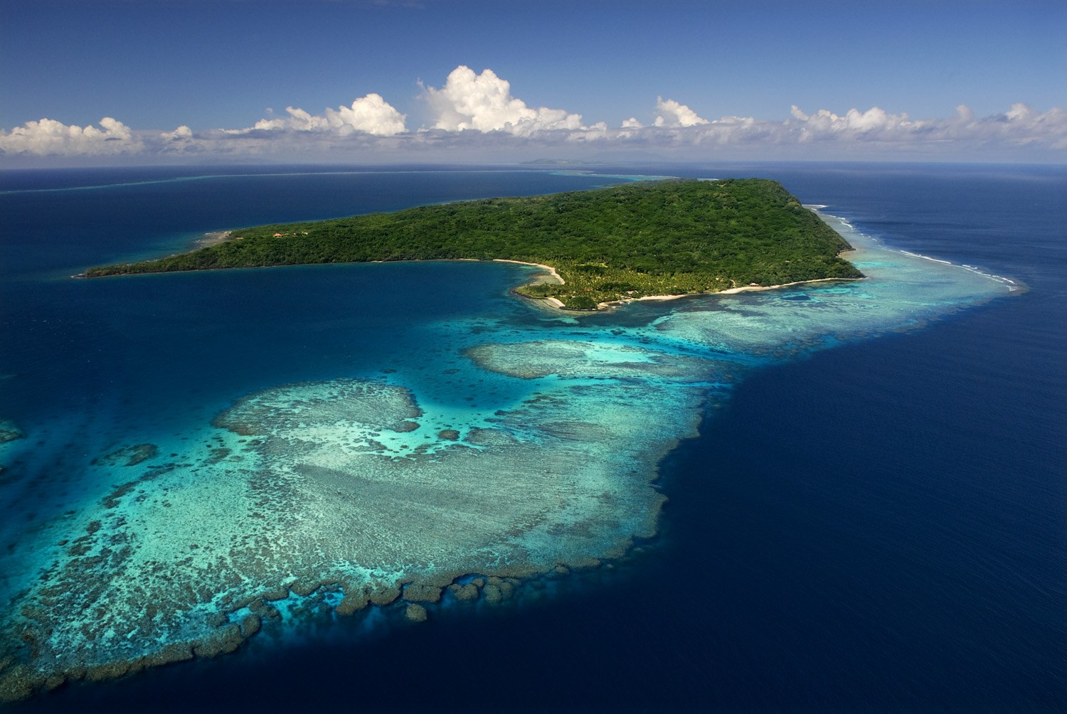 Aerial view of Wakaya Island surrounded by turquoise reef and blue ocean.