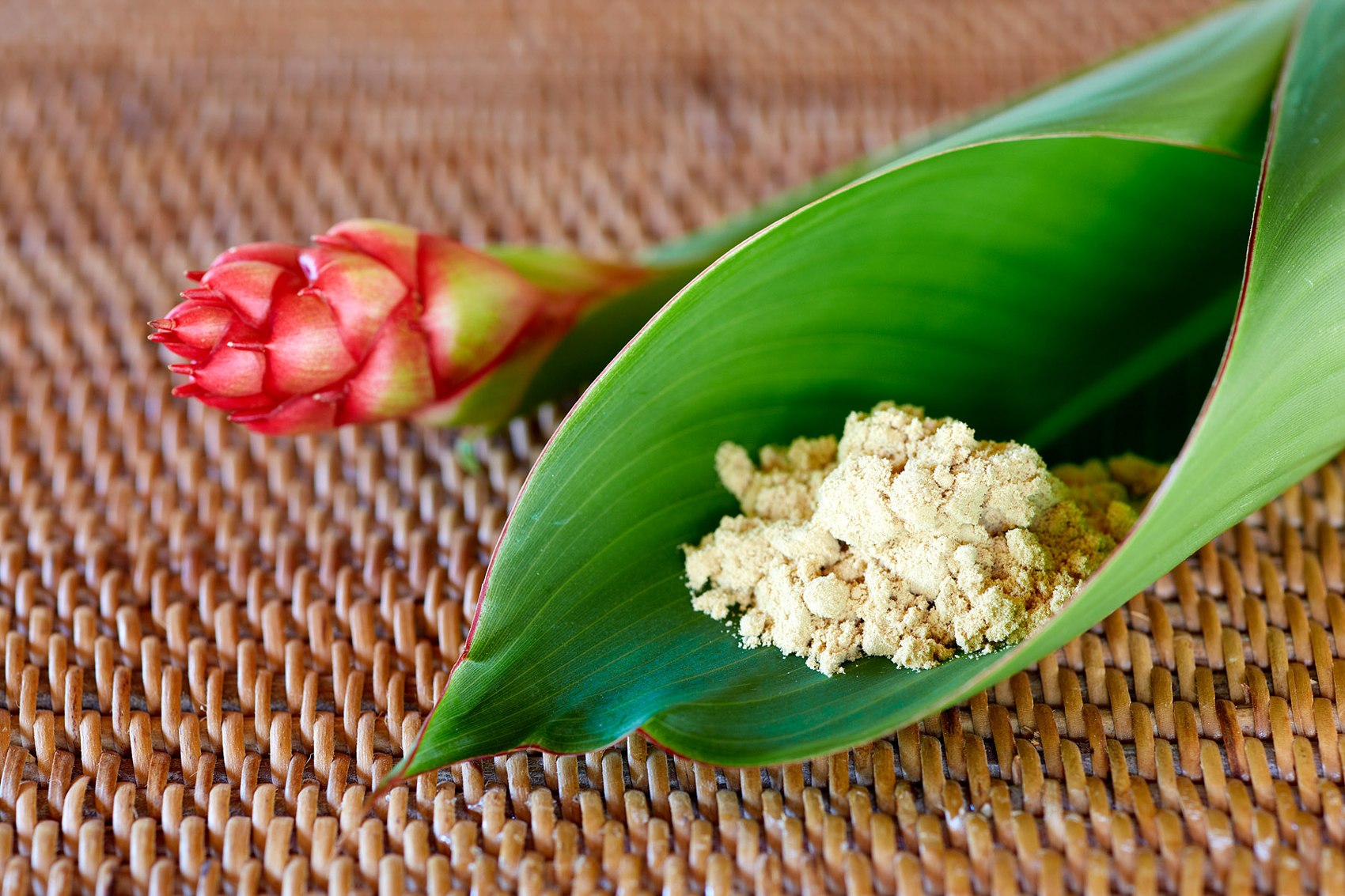 Pale ginger powder presented on a green leaf.