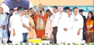 सार्वजनिक सभा में नेता का पारंपरिक तरीके से सम्मान करते कार्यकर्ता