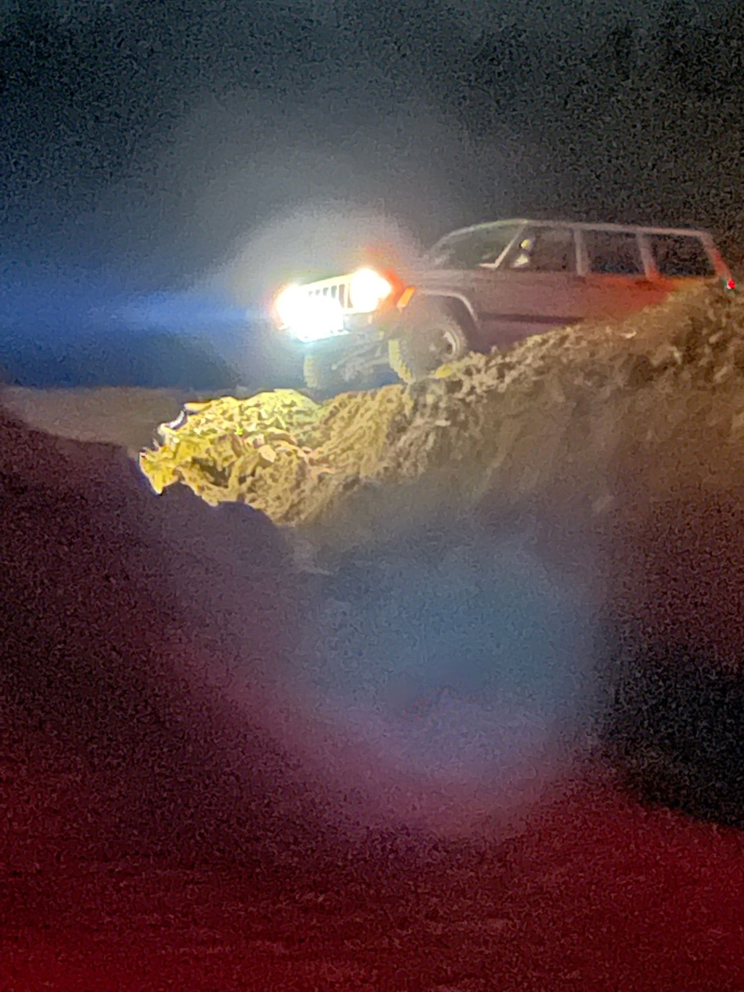 Luke's Jeep in a construction site on the edge of a mound of dirt.