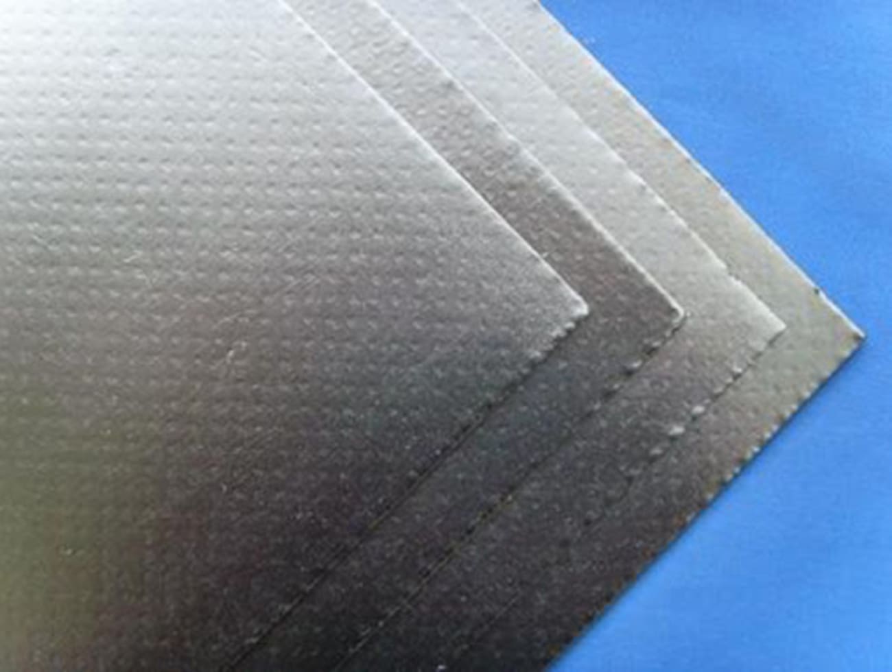 Ceramic fiber board with aluminum foil facing, showing stacked sheets of insulation material.