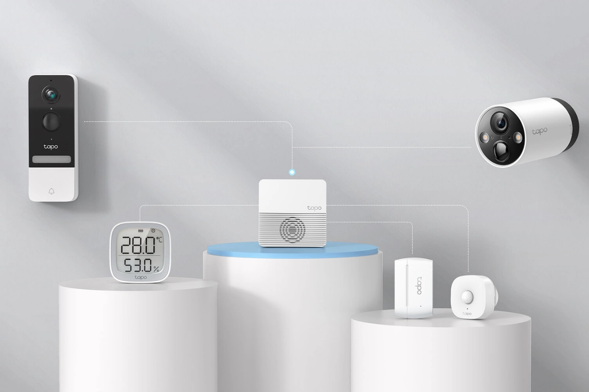 Smart home devices displayed on cylindrical pedestals, including a video doorbell, temperature monitor, hub, smart camera, and sensors, connected by dotted lines.