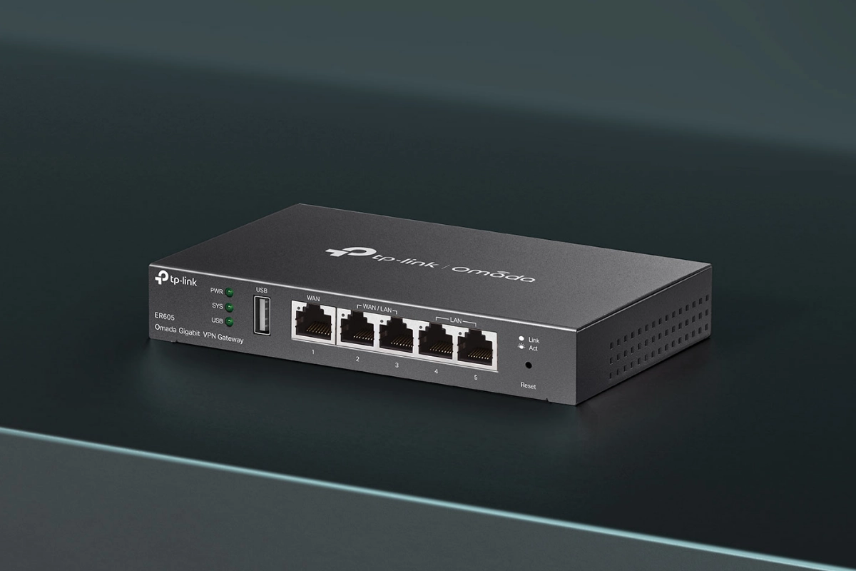 A sleek black TP-Link Omada ER605 VPN Gateway on a dark surface, featuring five Ethernet ports, two green LED indicators, and ventilation on the side.