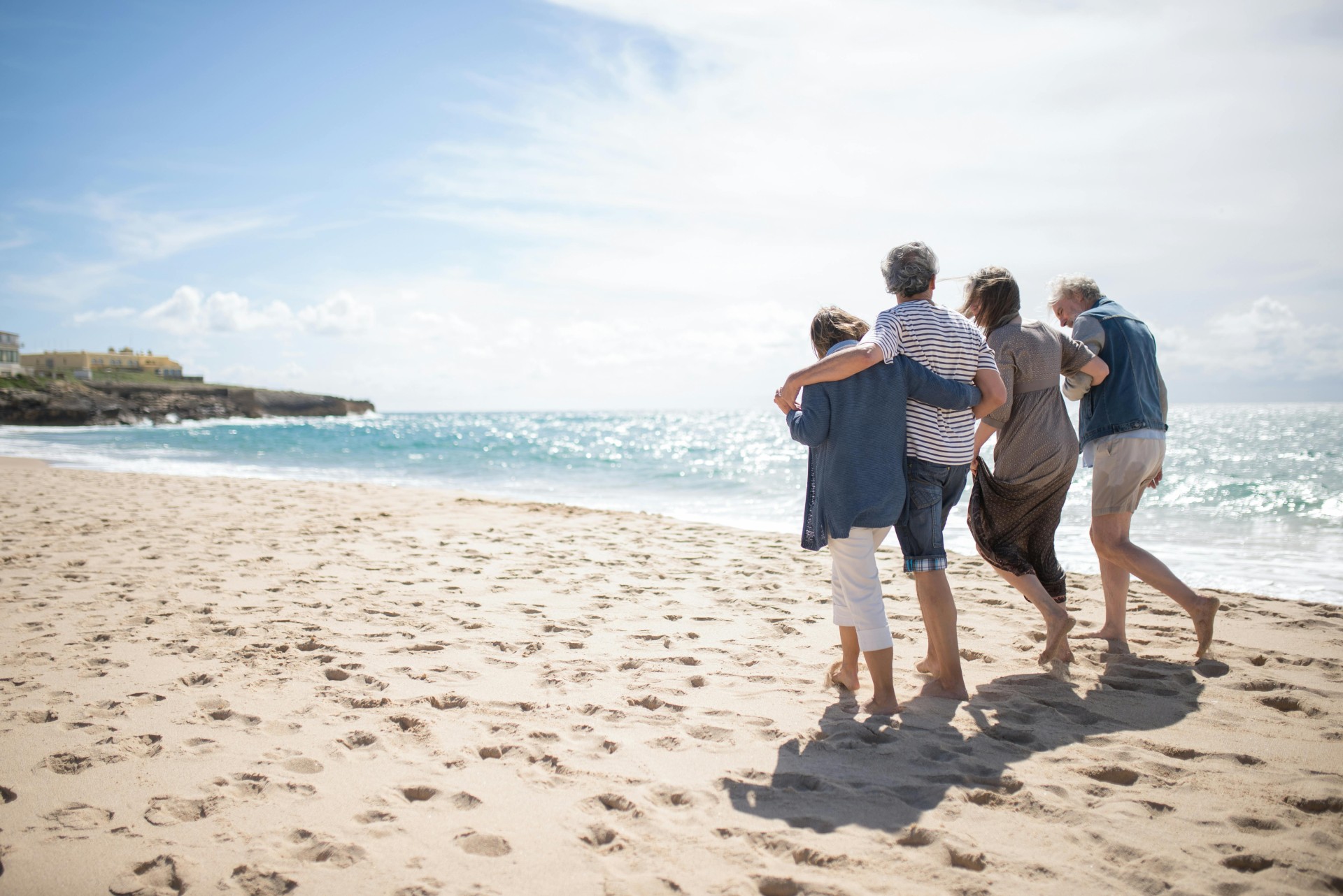 Un couple de seniors marchant sur une plage au coucher du soleil.