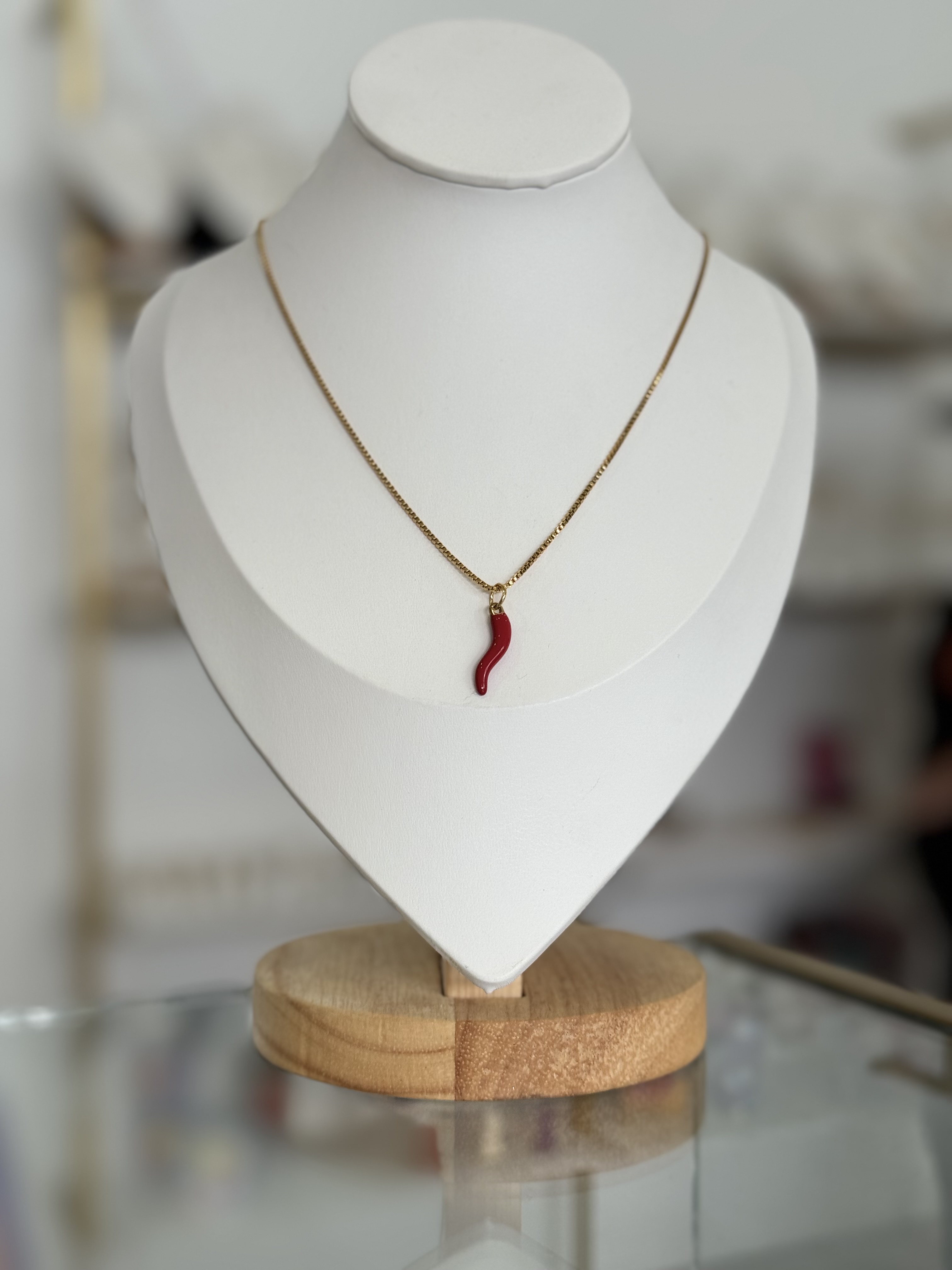 Collar dorado con dije corno rojo