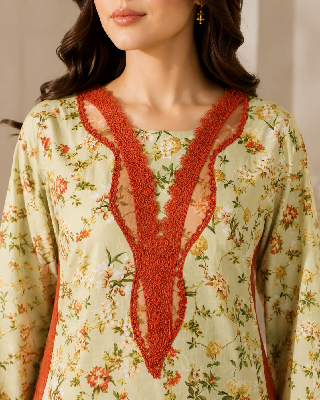 Close-up view of the split V-neckline with fabric loop buttons on a bright cyan blue botanical print shirt