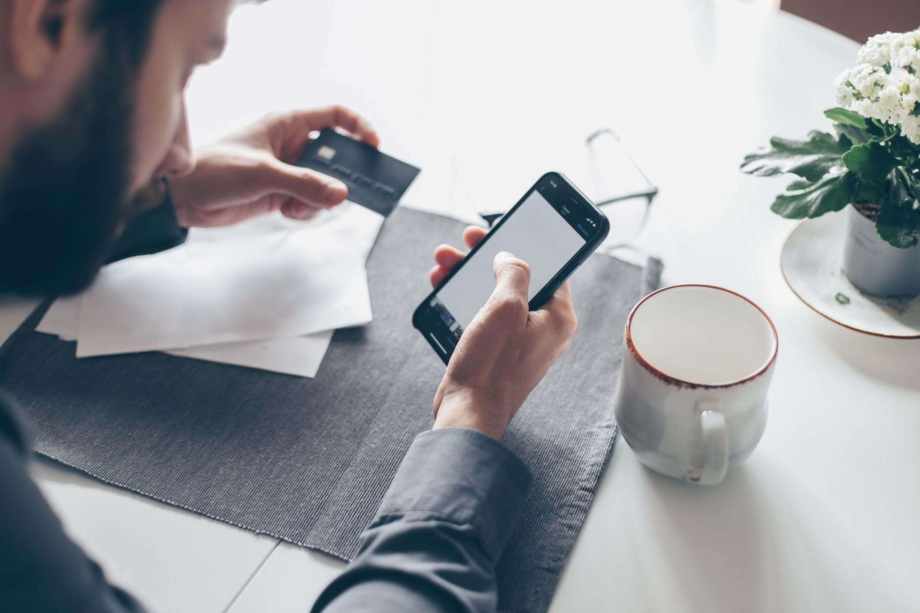 A person making an online payment with a smartphone and credit card
