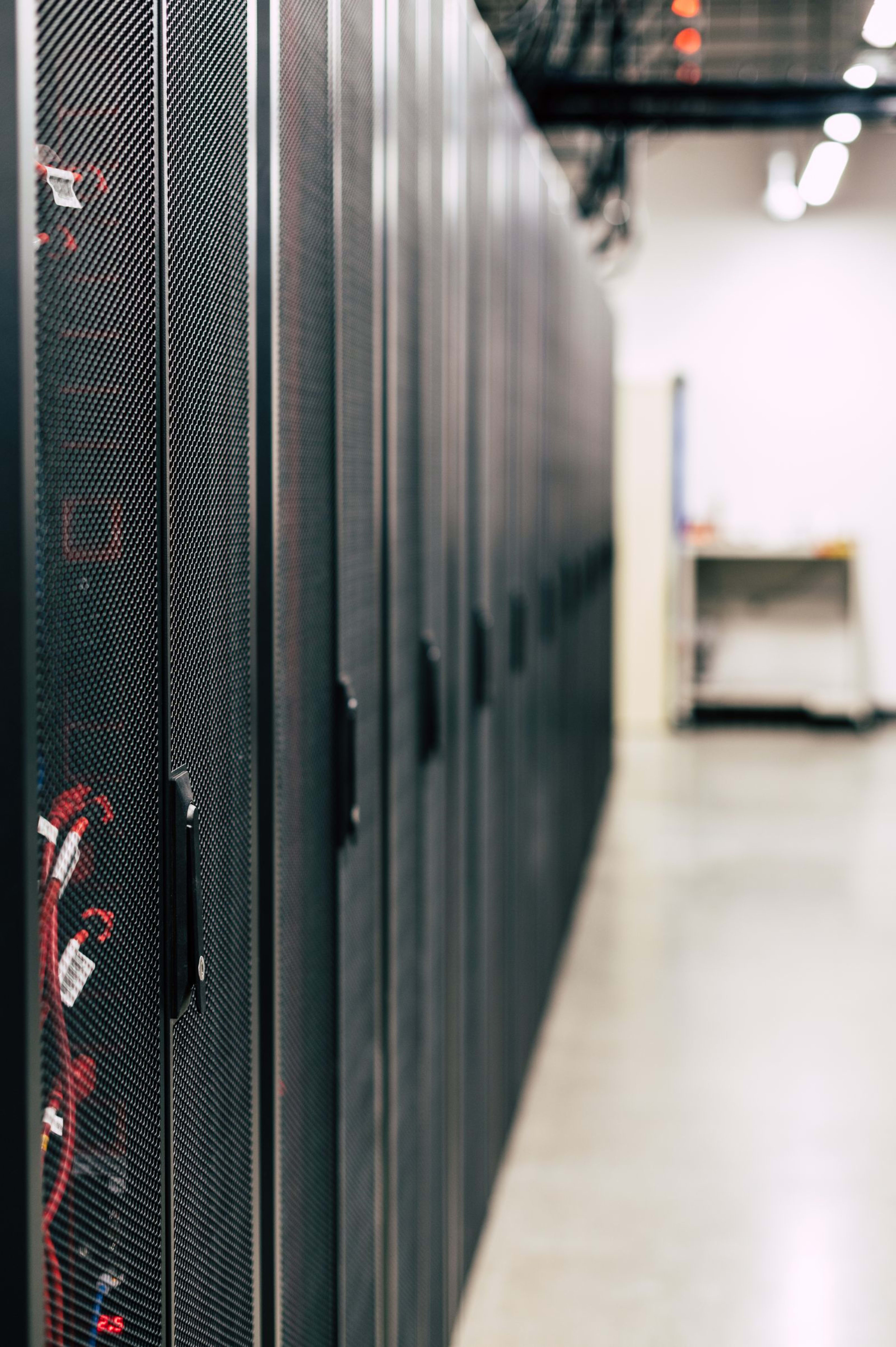 Interior of a hyperscale AI data center with rows of illuminated server racks
