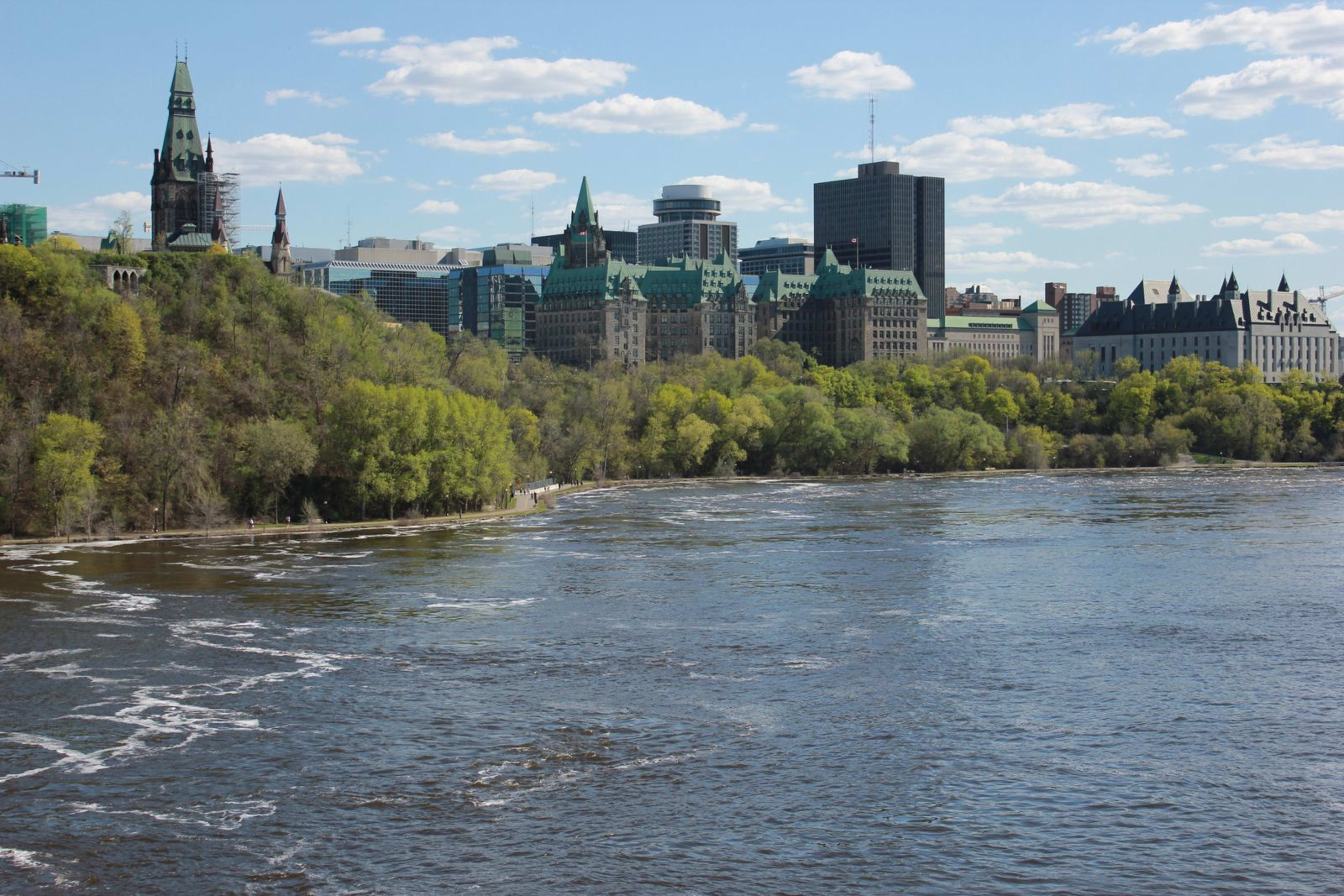 Ottawa's Parliament Hill buildings viewed across the Ottawa River on a clear day.