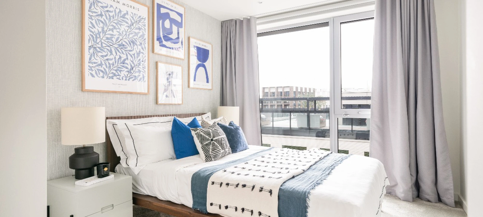 Thumbnail Bright and airy bedroom at Bloom Nine Elms with large windows, modern art, and blue and white decor