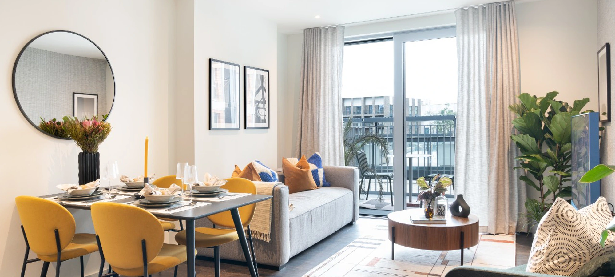 Thumbnail Modern living and dining area at Bloom Nine Elms with mustard yellow chairs, grey sofa, and balcony access
