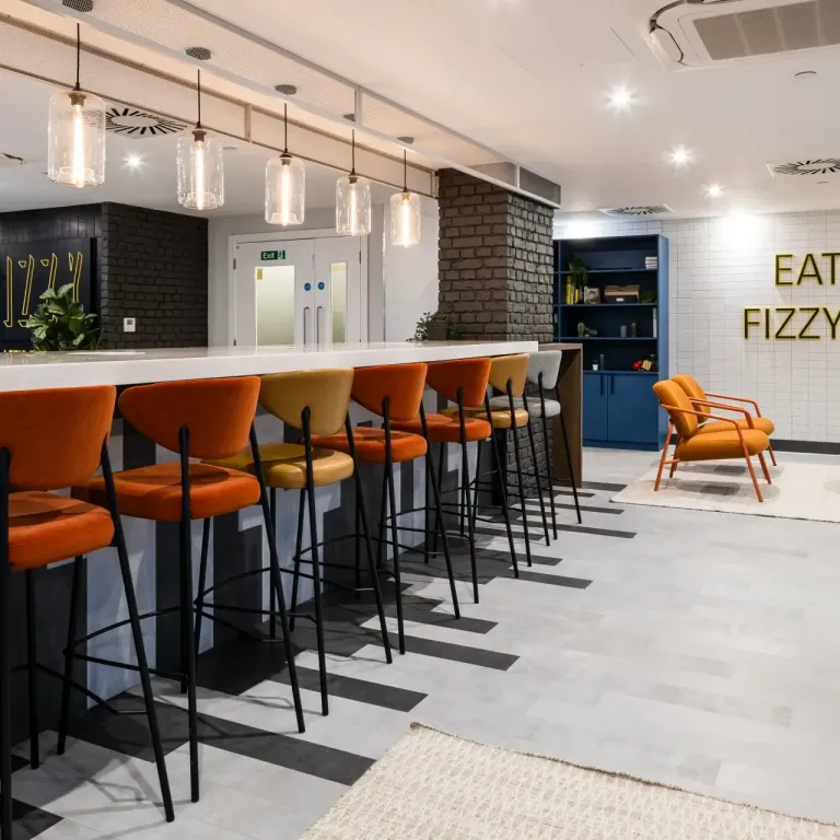 Thumbnail Fizzy East16 lounge with high-top dining bar, modern lighting, and bold seating