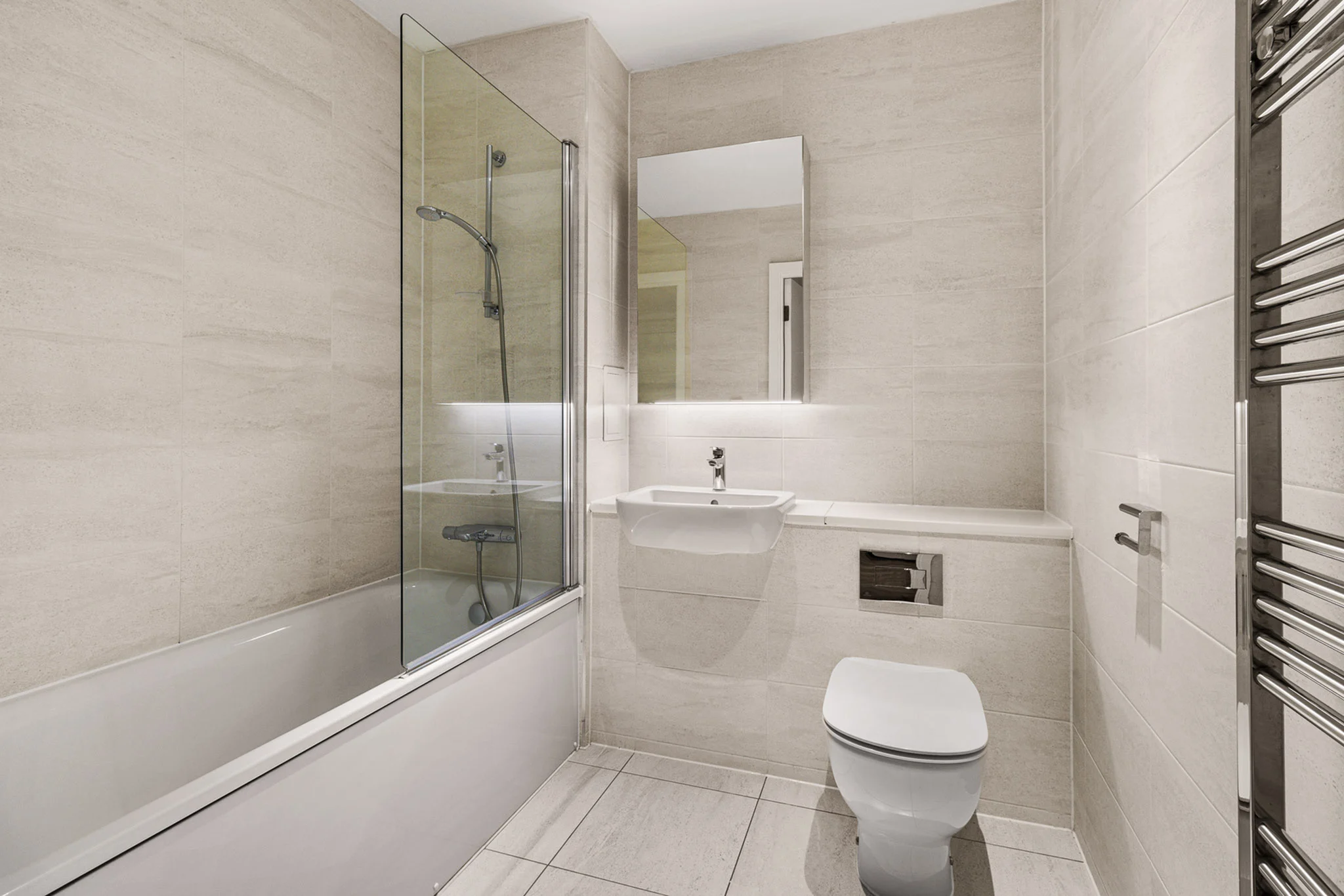 Thumbnail Neutral-toned bathroom at Fizzy East16 with bathtub, wall-mounted sink, and modern fittings