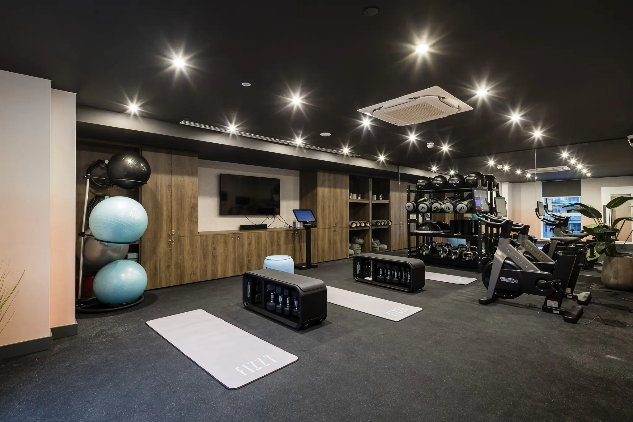 Thumbnail Well-equipped gym at Fizzy East16 with exercise bikes, weights, and yoga mats