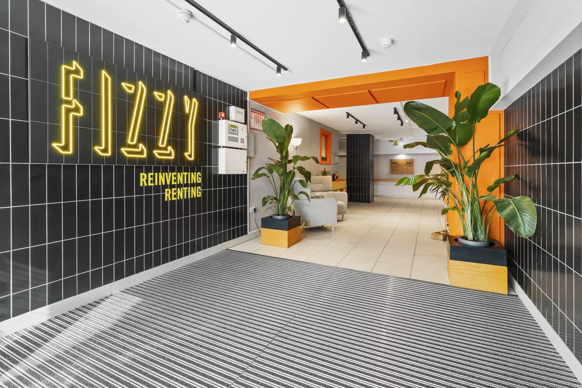 Thumbnail Bright and welcoming lobby at Fizzy Epsom with neon signage and indoor plants