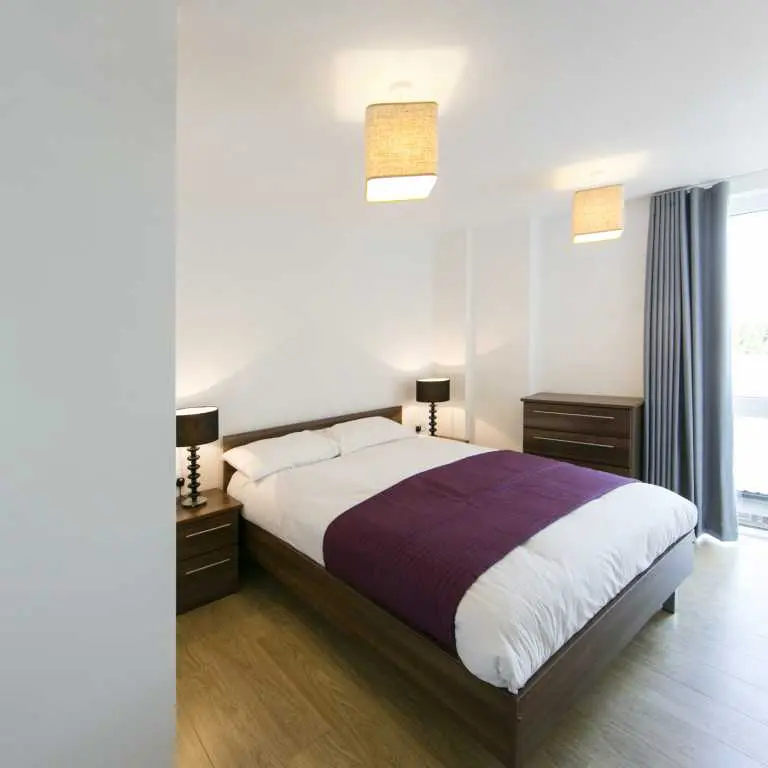 Thumbnail Minimalist bedroom at Fizzy Epsom with double bed, wood furniture, and soft lighting