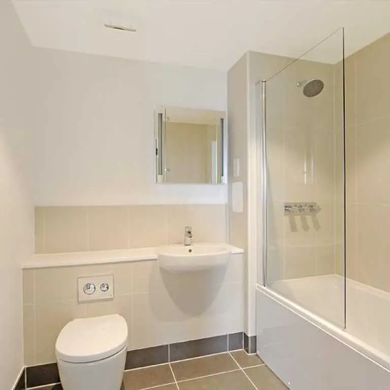 Thumbnail Neutral bathroom at Fizzy Epsom with bath-shower combo, floating sink, and tiled walls