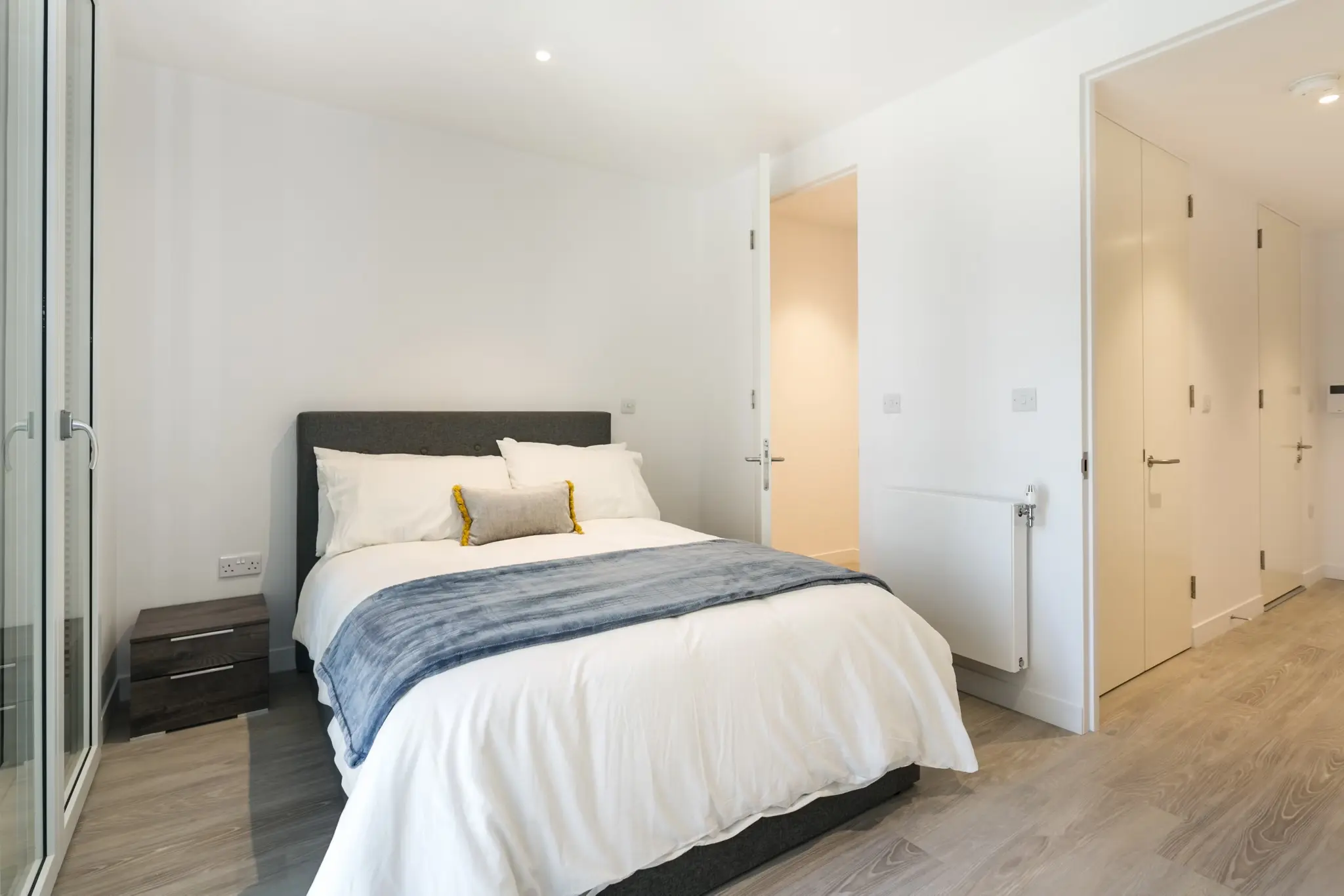 Thumbnail Modern bedroom at Fizzy Hayes featuring a neatly made bed with neutral tones and large windows