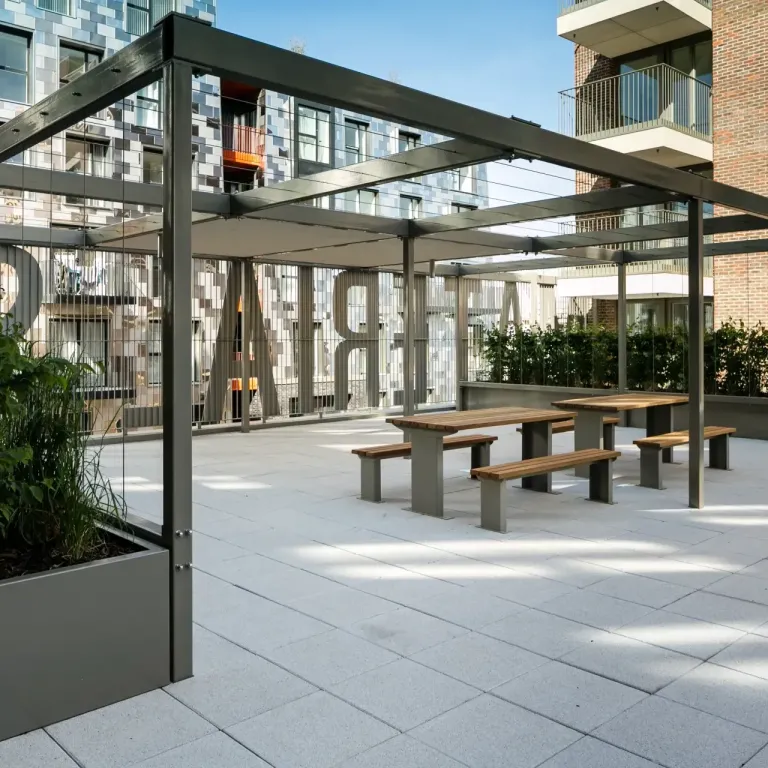 Thumbnail Outdoor communal terrace at Fizzy Hayes with covered seating and picnic tables surrounded by modern apartments