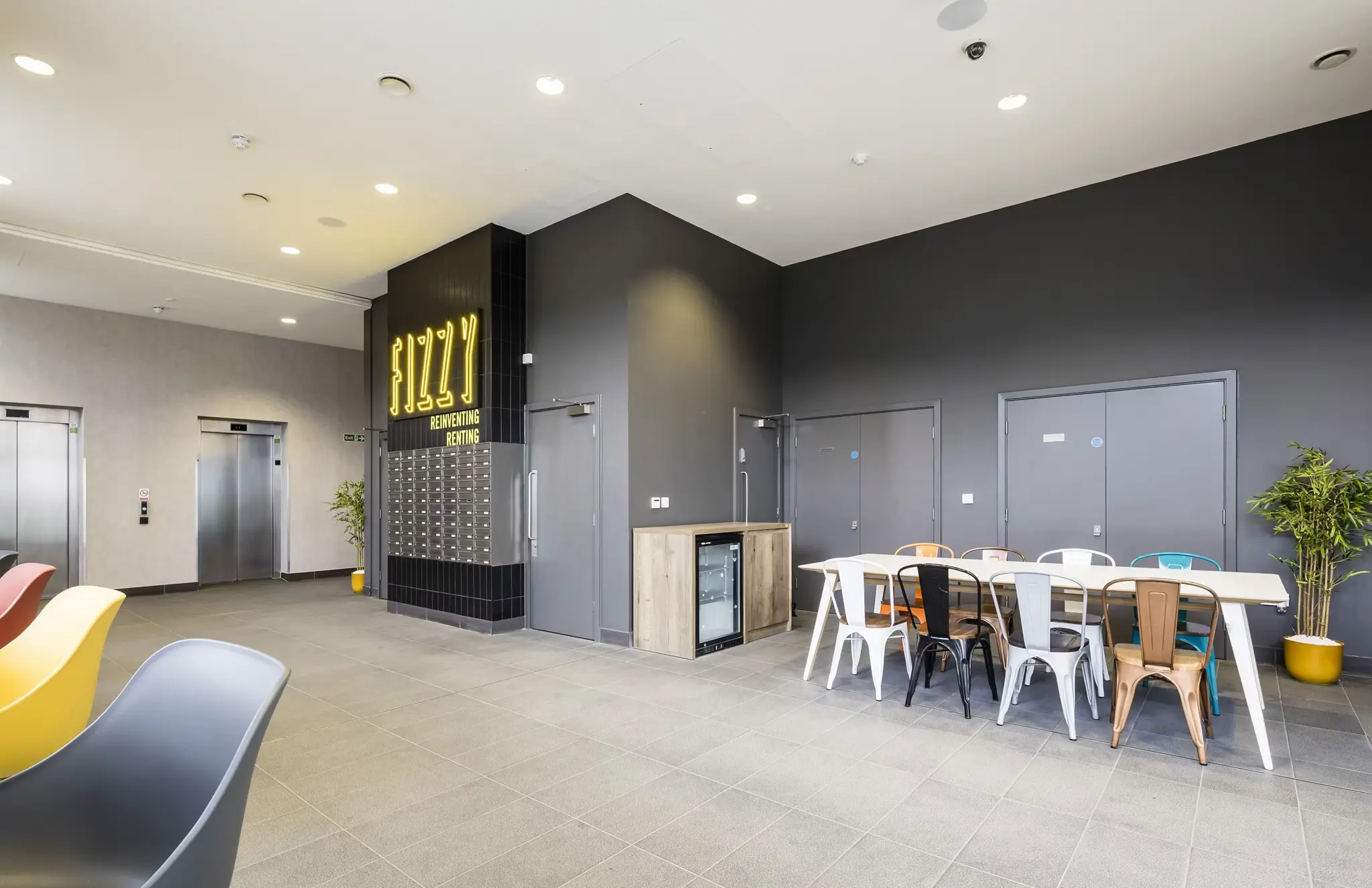 Thumbnail Fizzy Lewisham communal area with mailboxes, shared table, colourful chairs, and elevator access