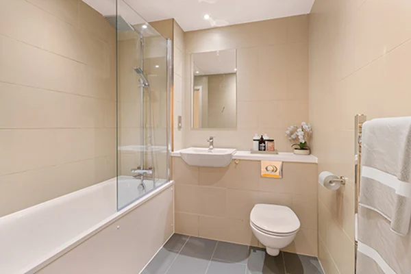Thumbnail Modern bathroom at Fizzy Lewisham with bathtub shower combo, wall-mounted sink and toilet, and neutral tiles