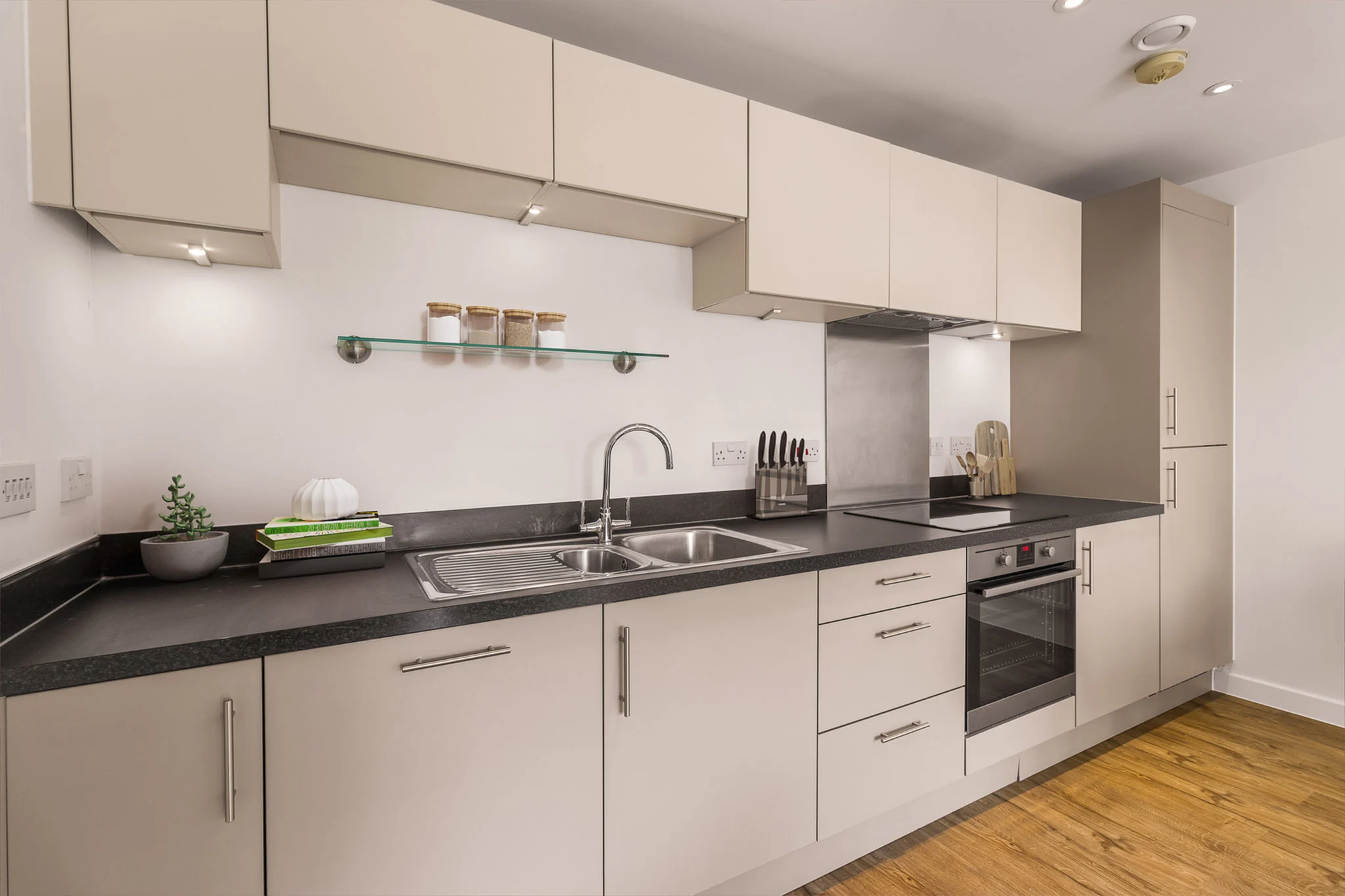 Thumbnail Modern kitchen at Fizzy Poplar with beige cabinets, black countertops, and integrated appliances