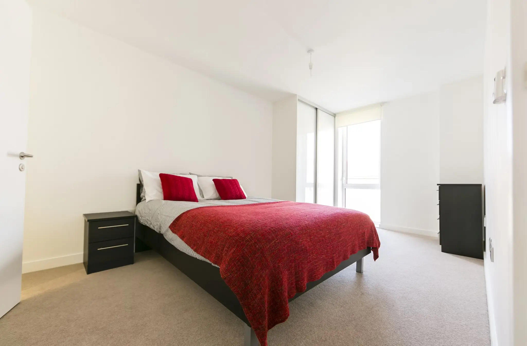 Thumbnail Bright bedroom at Fizzy Stepney Green with minimalist decor, red bedding, and built-in wardrobe
