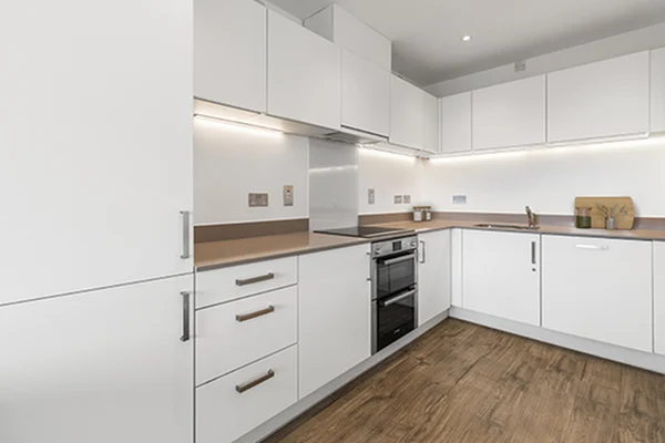 Thumbnail Modern white kitchen at Fizzy Stepney Green with integrated appliances, wooden flooring, and under-cabinet lighting