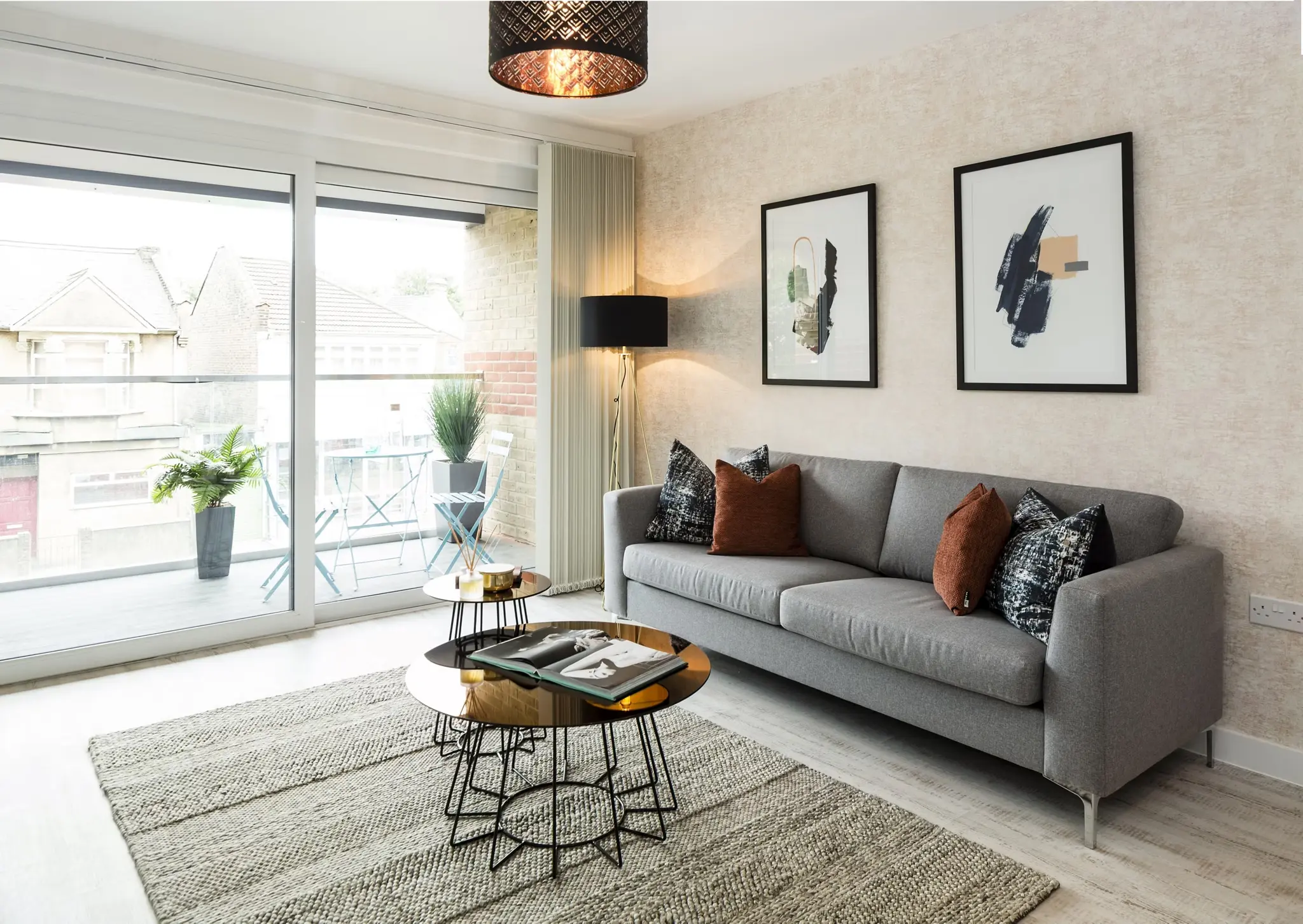 Thumbnail Sophisticated decor with grey sofa, stylish artwork, and balcony