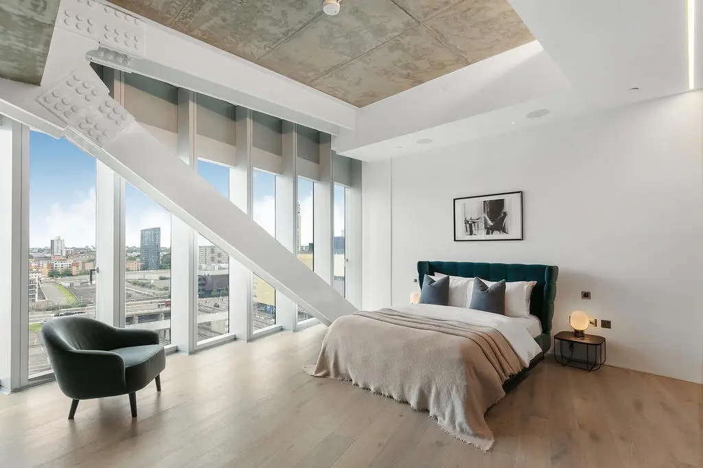 Thumbnail Modern bedroom at Manhattan Loft Gardens with floor-to-ceiling windows and exposed steel beam