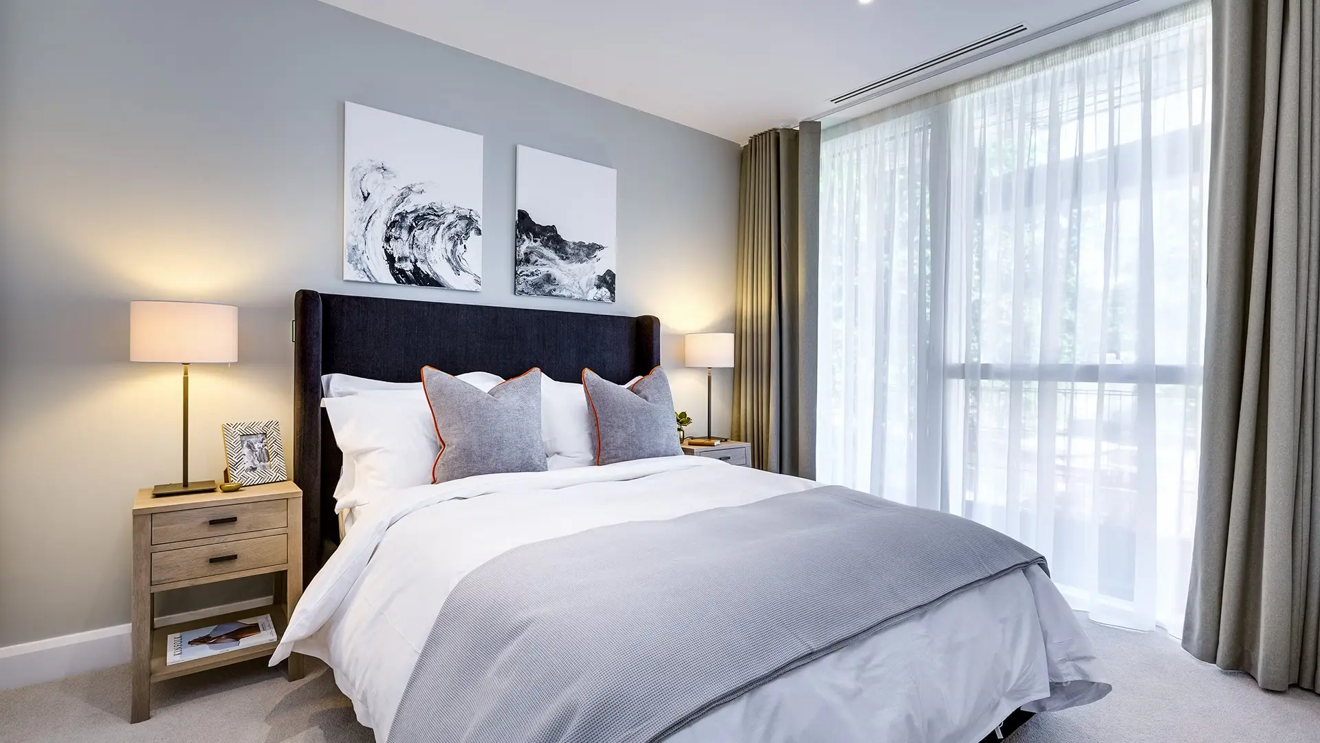 Thumbnail Modern bedroom at Sailmakers with upholstered headboard, soft grey tones, and floor-to-ceiling windows