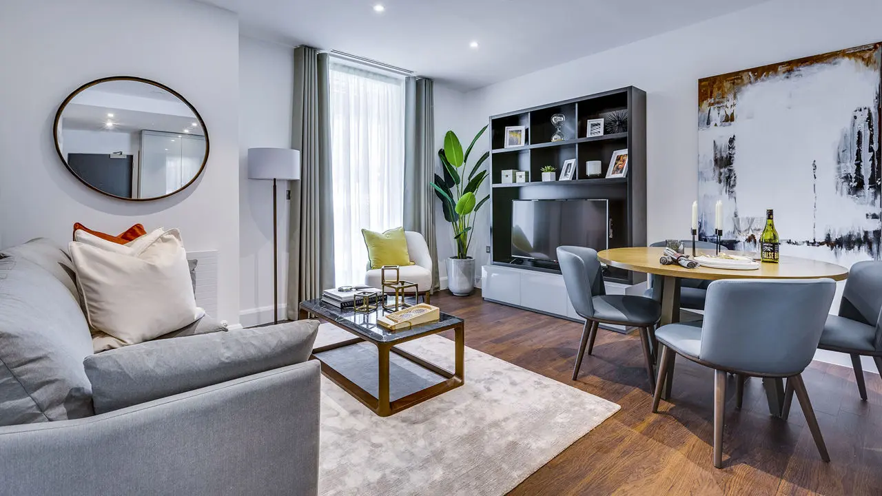 Thumbnail Contemporary living and dining area at Sailmakers with grey sofa, round dining table, dark wood flooring, and modern she