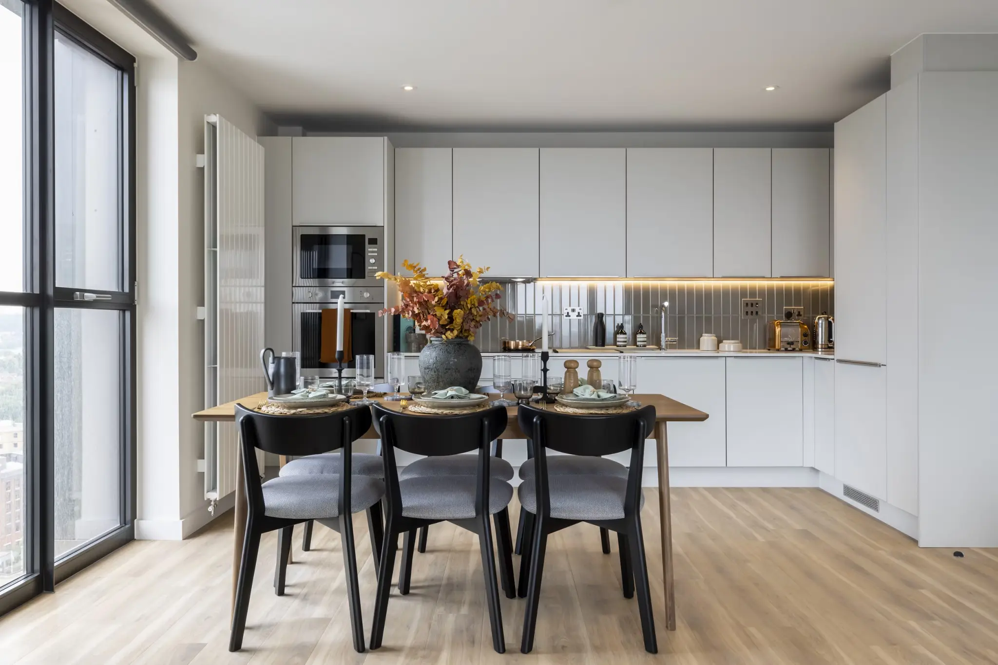 Thumbnail Modern kitchen and dining area at Ten Degrees with integrated appliances and large windows