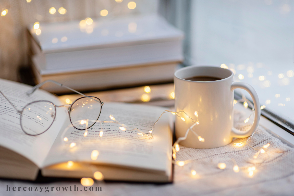 Stack of cozy comfort books with fairy lights