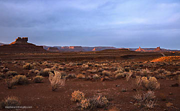 Landscape photograph of sunset at Valley of the Gods, with red rocks yellow grasses and blue sky