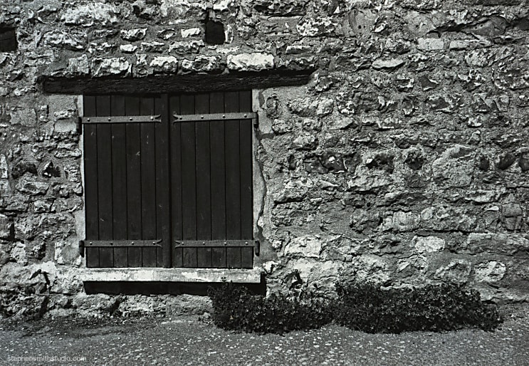 Black and white photograph of old doorway on old stone house