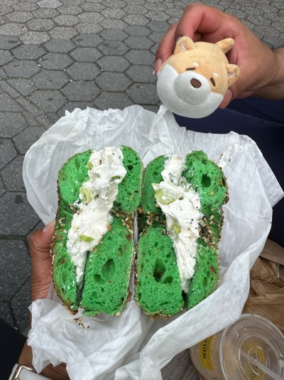 Eating the greenest bagels she's ever seen at Union Square Park in New York