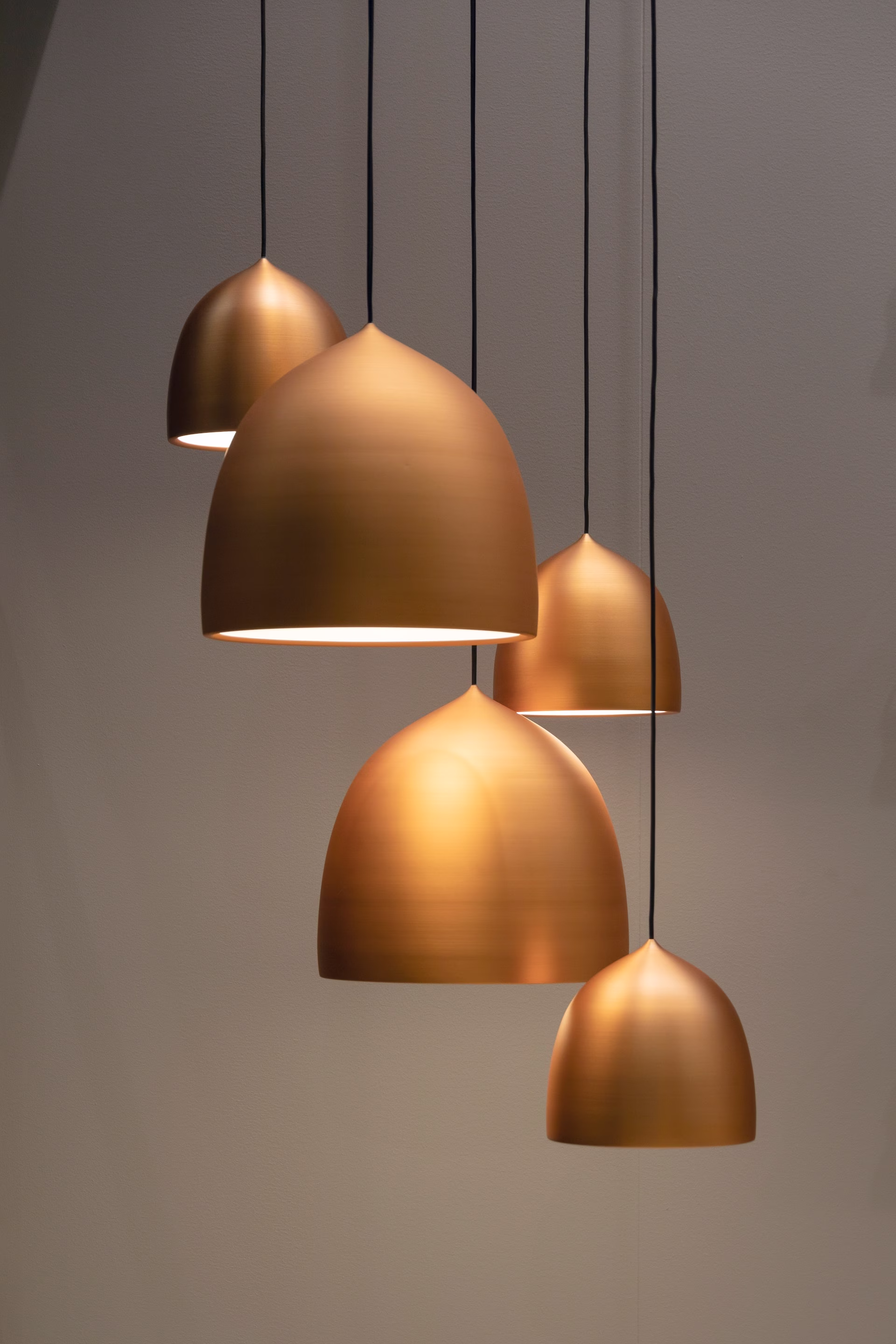Four copper pendant lights hanging from the ceiling